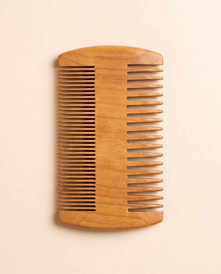 A dual-sided sandalwood beard comb